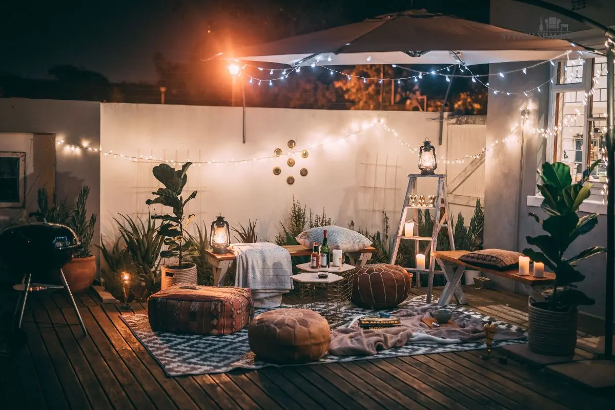 Patio at night layered with string lights, lanterns, and path lighting