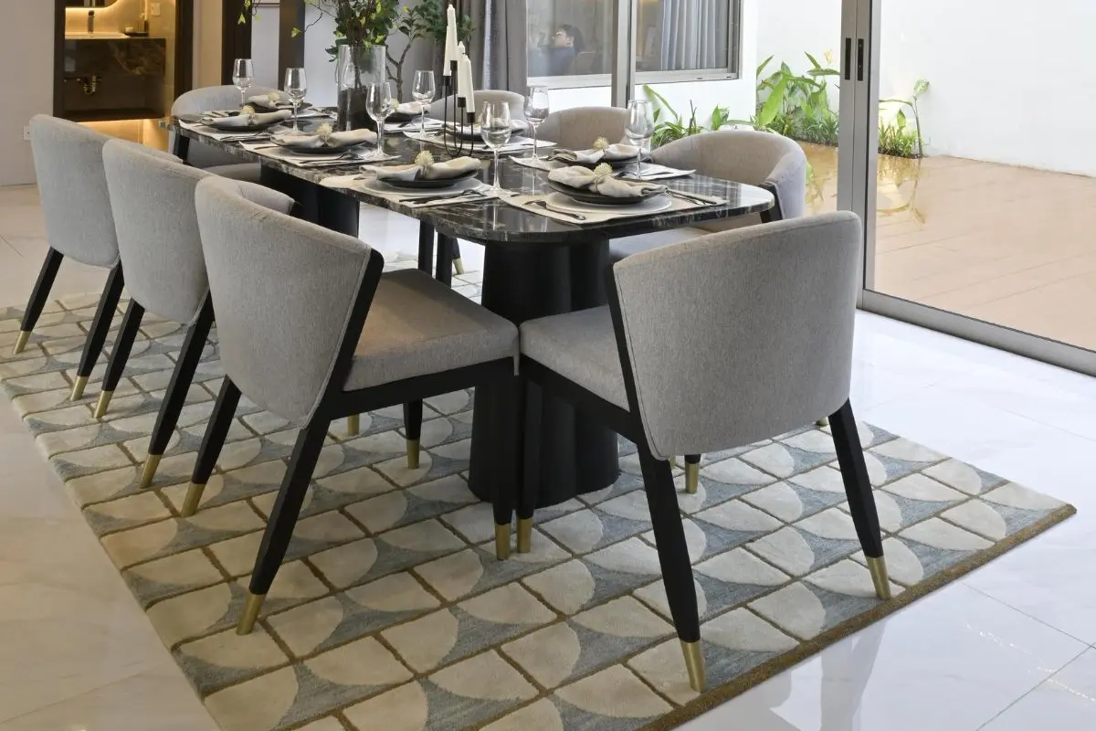 Dining table grounded by a rug sized to fit the chairs